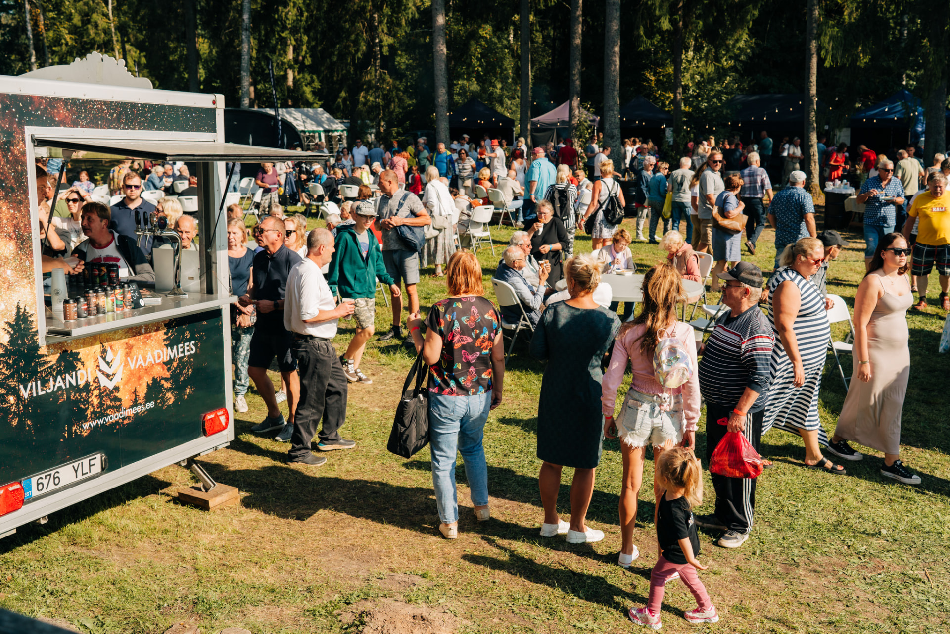 Festivalirahvas toidukäru juures metsa all Ulgel